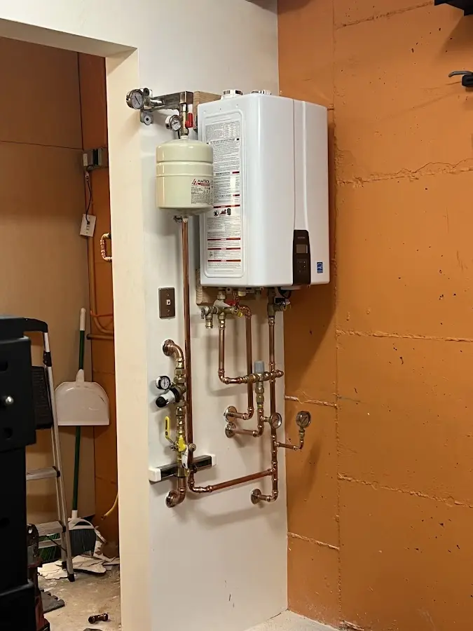 Plumbing technician inspecting water heater connections in Martinsville